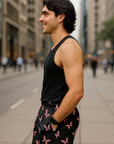 Man in black tank top and butterfly patterned shorts standing on a city street