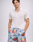 Man wearing a white polo shirt and RF-Wear Men's Floral Shorts in Sky-Blue/Red/Peach