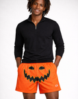 Man wearing a black quarter zip and RF-Wear Men's Mesh Jack-O-Lantern Face Shorts in Orange/Black
