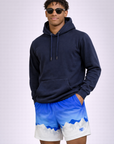 Man wearing a dark blue hoodie and RF-Wear Men's Mesh Mountain Skyline Shorts in Blue/White