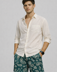Man wearing a cream shirt and RF-Wear Men's Mesh Paisley Shorts in Pine-Green/Cream