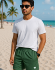 Man on beach wearing a white t-shirt and RF-Wear Men's Mesh Solid Color Shorts in Military-Green