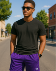 Man wearing a black t-shirt and RF-Wear Men's Mesh Solid Color Shorts in Purple