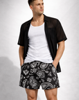 Man wearing a white tank top and RF-Wear Men's Paisley Pocket Shorts in Black/Whitew