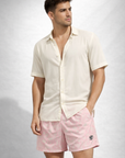 Man wearing a cream shirt and RF-Wear Men's Paisley Shorts in Pink/Cream