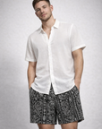 Man wearing a white shirt and RF-Wear Men's Paisley Stripe Shorts in Black