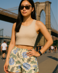 Woman wearing a cream crop top and RF-Wear women's carnation shorts in cream/blue with a bridge in the background