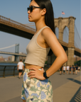 Woman wearing a cream crop top and RF-Wear women's carnation shorts in cream/blue with a bridge in the background