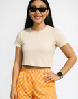 Woman wearing a top and RF-Wear Women's Checkered Shorts in Peach