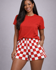 Woman wear a red top and red and white checkered shorts