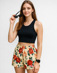 Woman wearing a black top and RF-Wear Women's Floral Shorts in Cream/Red/Peach