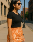 Woman standing in city wearing RF-Wear Women's Paisley Shorts - Apricot/Cream - Side View