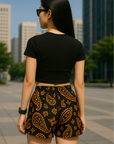 Woman in the city wearing RF-Wear Women's Paisley Shorts - Black/Orange - Back View