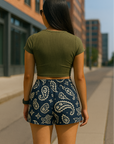 Woman on city sidewalk wearing RF-Wear Women's Paisley Shorts - Navy/Cream - Back View