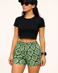 Woman wearing a black top and RF-Wear Women's Snakeskin Shorts in Green