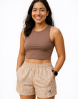 Woman wearing a brown shirt and RF-Wear Women's Snakeskin Shorts in Tan