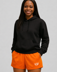 woman wearing a black hoodie and RF-Wear Women's Solid Color Shorts in Orange