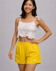 Woman wearing a white top and RF-Wear Women's Solid Color Shorts in Yellow