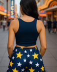 Woman wearing a navy blue tank top and shorts with star pattern on a city street.