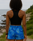 Person wearing blue shorts with a starry night design by the ocean