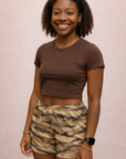 Woman wearing a brown cropped top and RF-Wear Women's Tiger Camo Shorts Tan