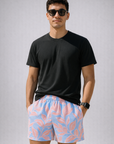 Man wearing a black t-shirt and RF-Wear Men's Mesh Floral Hawaiian Shorts in Blue/Pink