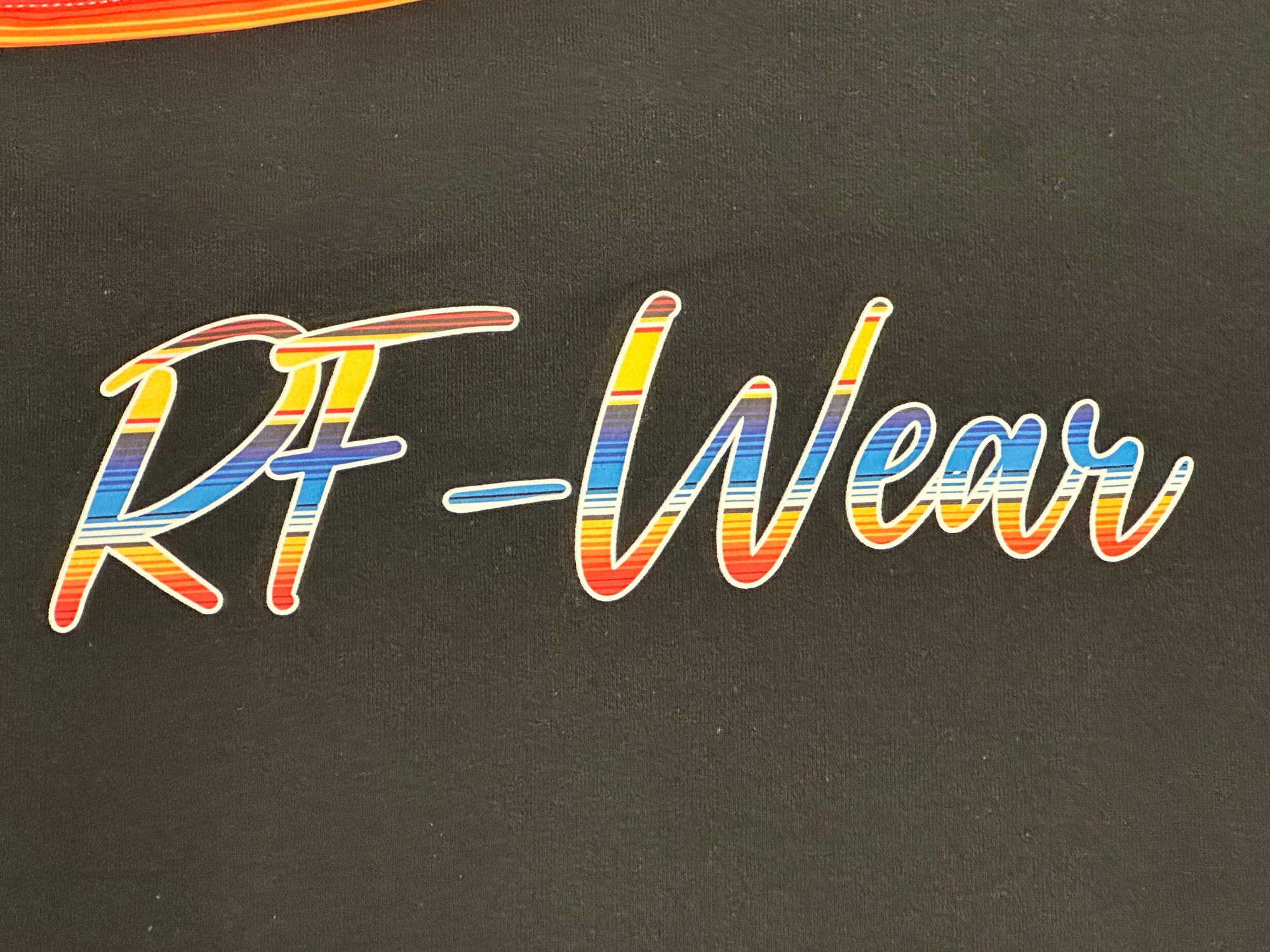 Close up of RF-Wear graphic on the front of the black Baja hoodie.