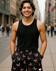 Man wearing a black tank top and butterfly patterned shorts on a city street