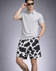 Man wearing a polo top and RF-Wear Men's Mesh Animal Print Shorts  - Cow - Black/White
