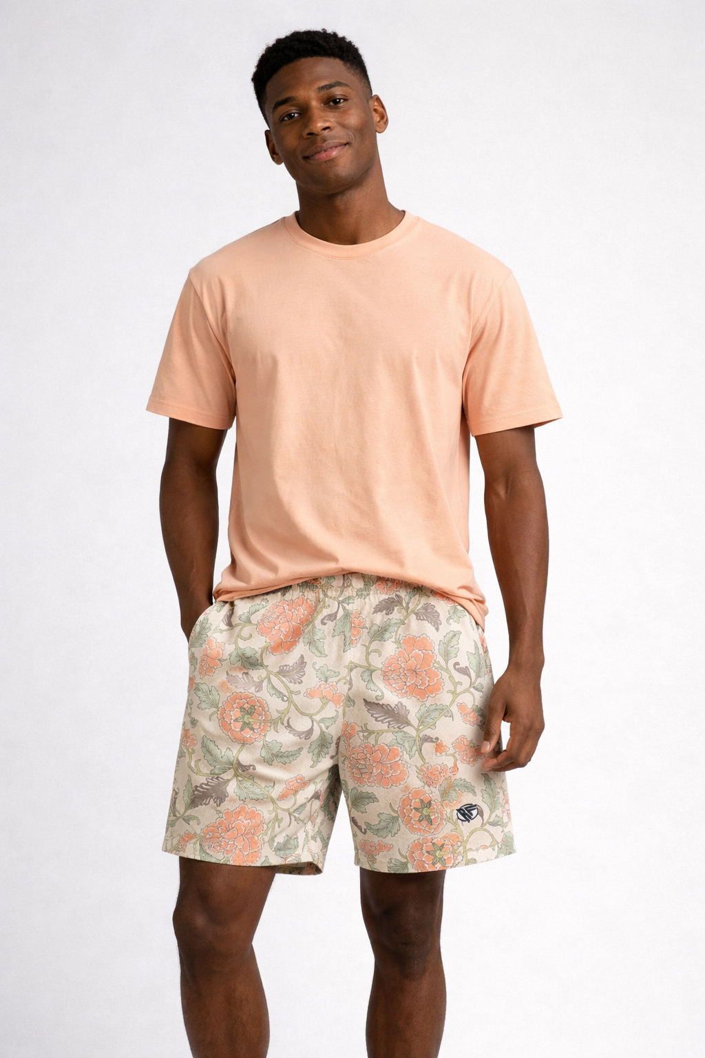 Man wearing a peach t-shirt and RF-Wear Men's Mesh Carnation Shorts in Cream/Peach