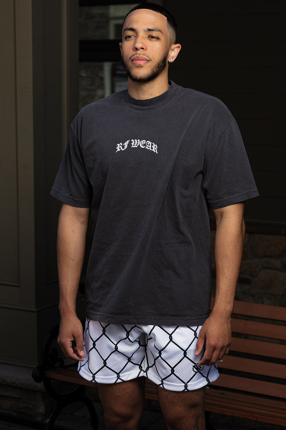 Man wearing a black t-shirt and RF-Wear Men's Mesh Chain Link Shorts in White/Black 