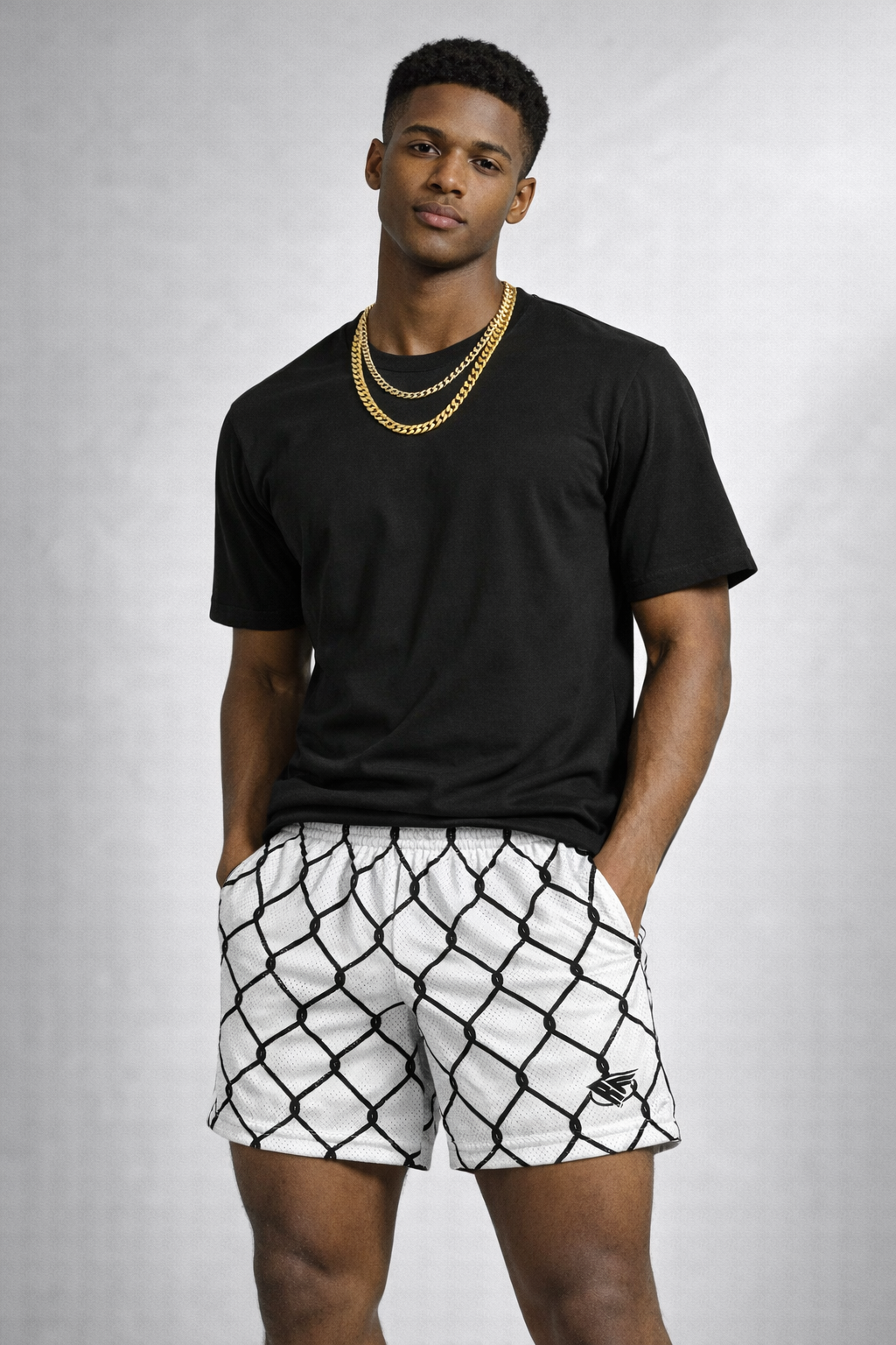 Man wearing a black t-shirt and RF-Wear Men's Mesh Chain Link Shorts in White/Black