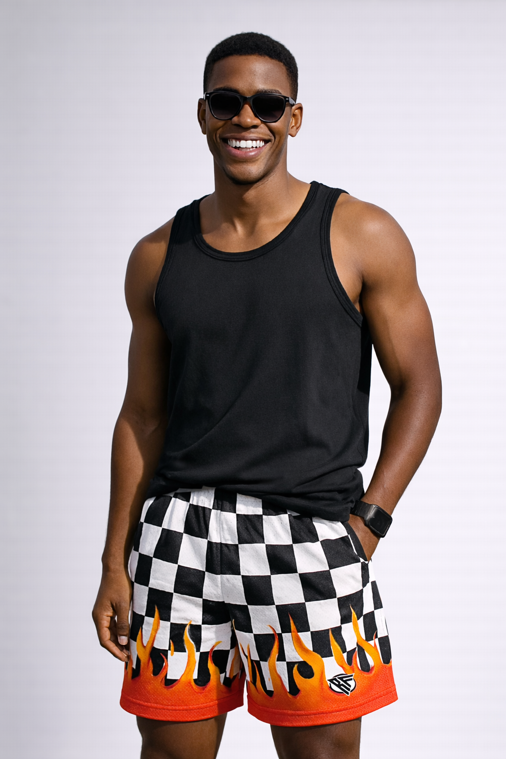 Man wearing a black tank top and RF-Wear Men's Mesh Checkered Flame Shorts in Black/White Red Flames 