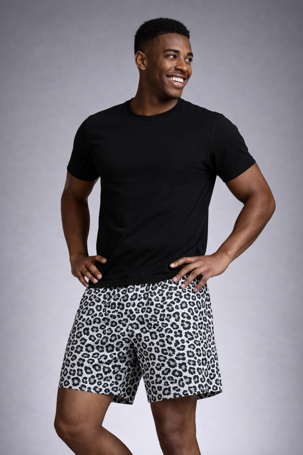 Man wearing a black t-shirt and RF-Wear Men's Mesh Animal Print Shorts - Cheetah in White