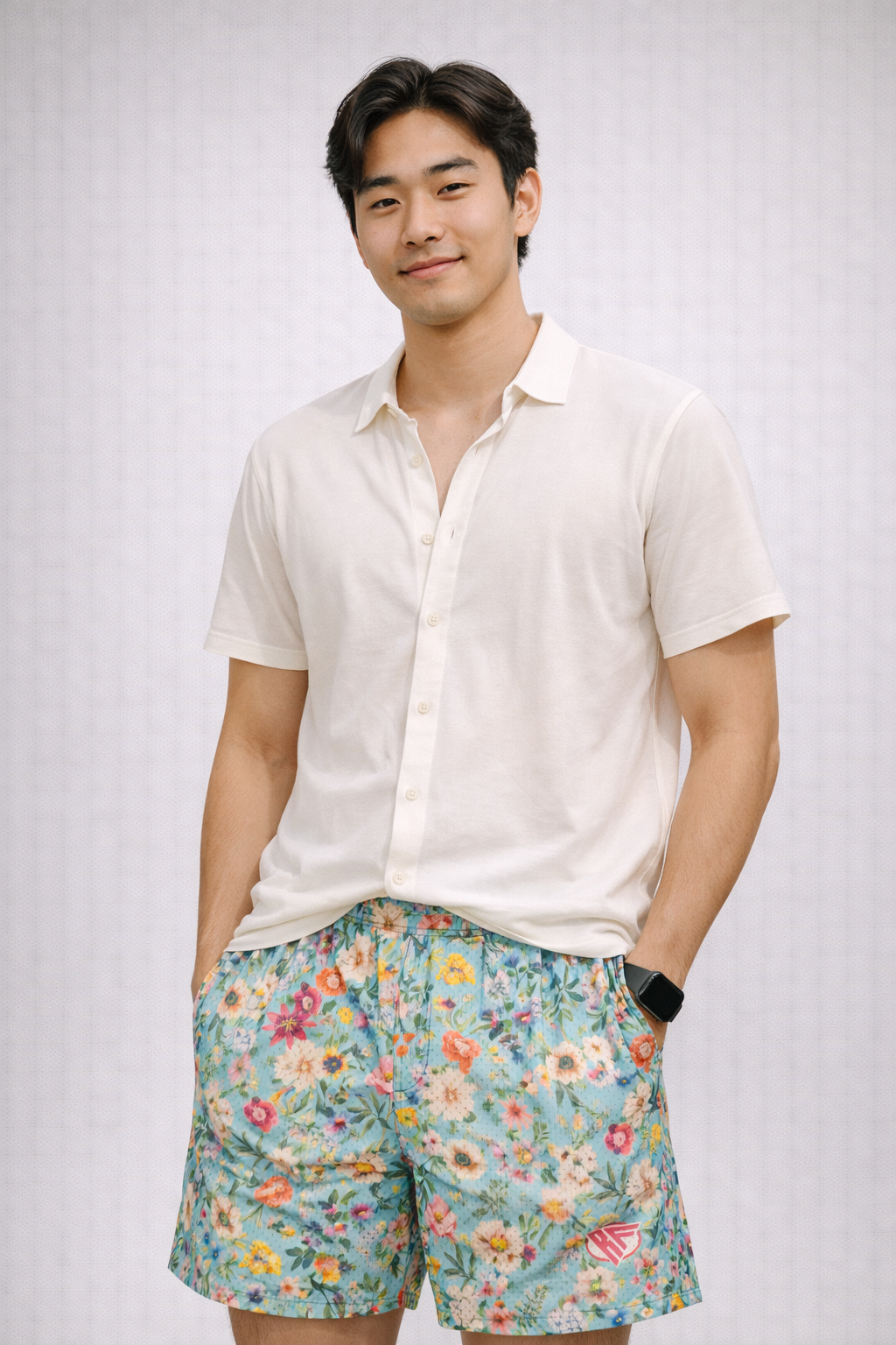 Man wearing a white top and RF-Wear Men's Mesh Floral Shorts in Teal/Multicolor
