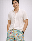 Man wearing a white top and RF-Wear Men's Mesh Floral Shorts in Teal/Multicolor