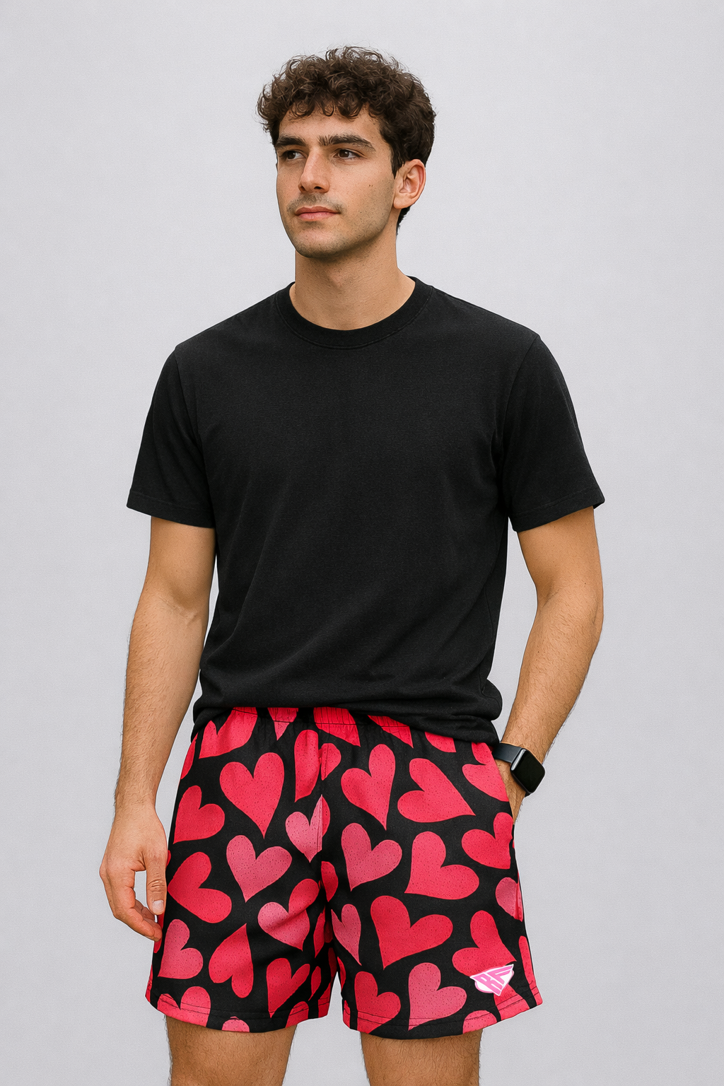 Man wearing a black t-shirt and RF-Wear Men's Mesh Heart Shorts in Black/Pink