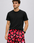 Man wearing a black t-shirt and RF-Wear Men's Mesh Heart Shorts in Black/Pink
