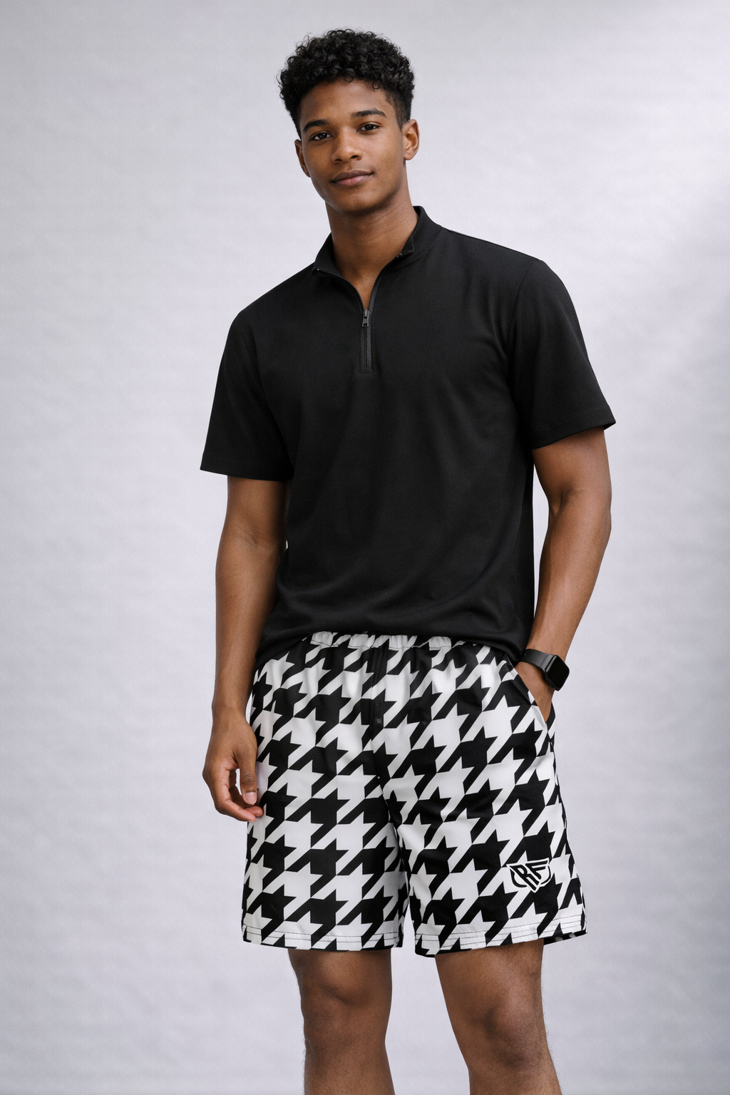 Man wearing a black short sleeve quarter zip top and RF-Wear Men's Mesh Houndstooth Shorts in Black/White 