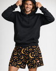 Man wearing a black hoodie and RF-Wear Men's Mesh Jack-O-Lantern 2.0 Shorts in Black/Orange