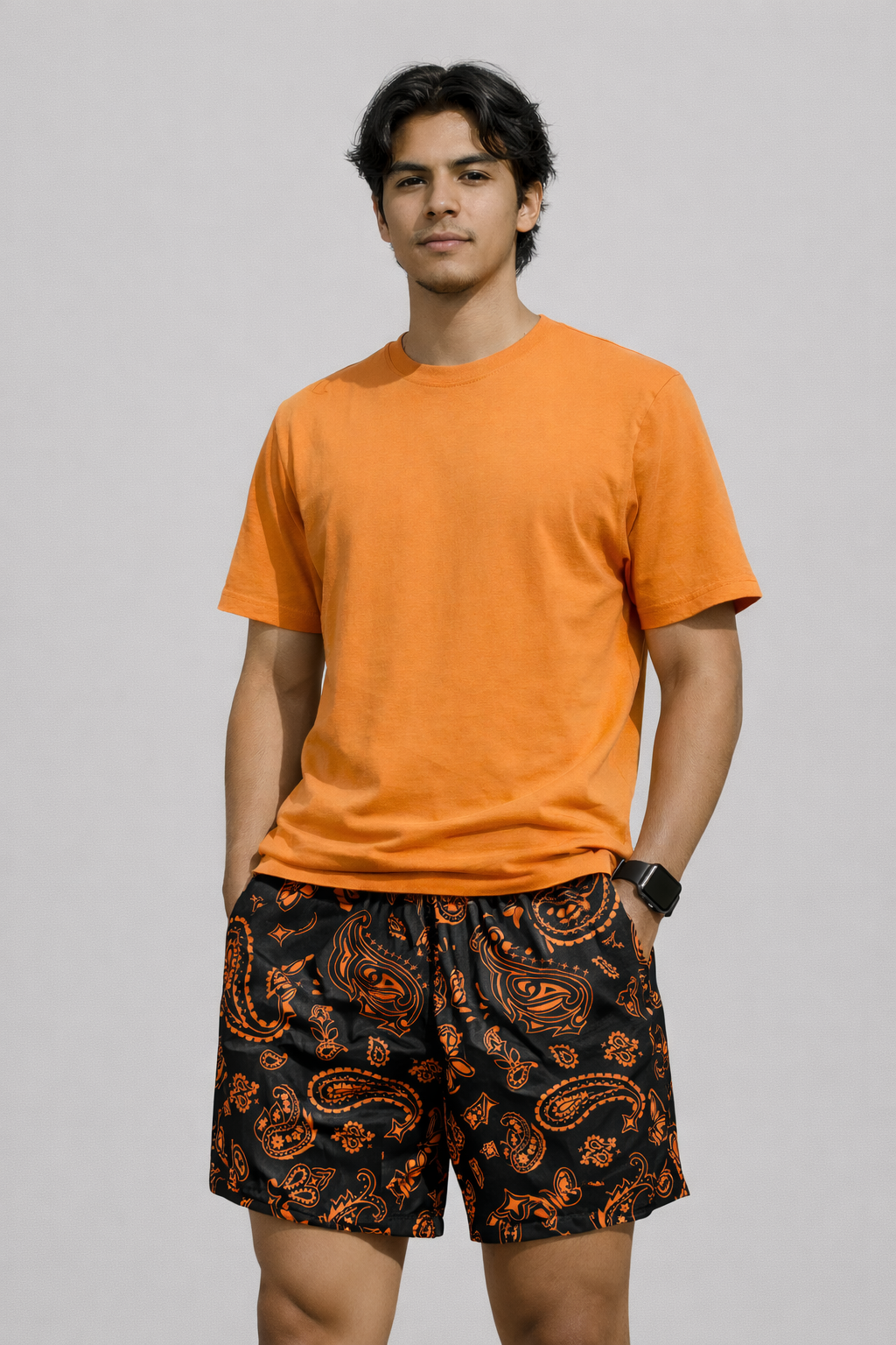 Man wearing a orange t-shirt and RF-Wear Men's Mesh Paisley Shorts in Black/Orange 