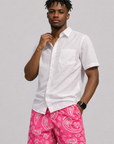 Man wearing a white shirt and RF-Wear Men's Mesh Paisley Shorts in Fuchsia/White