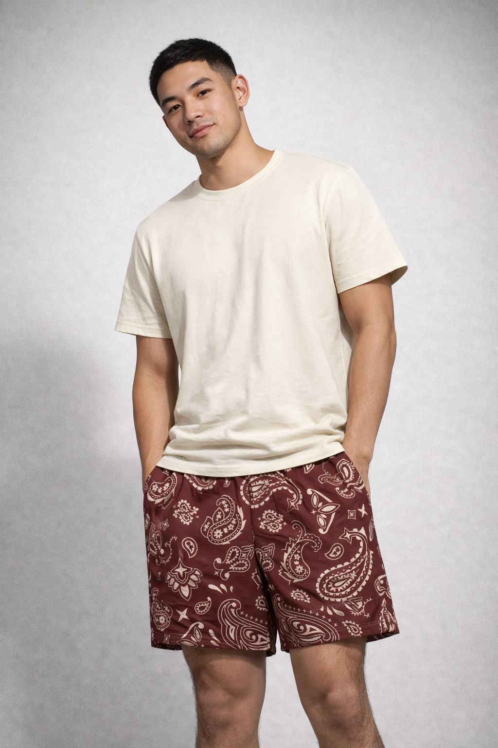 Man wearing a cream t-shirt and RF-Wear Men's Mesh Paisley Shorts in Merlot/Cream
