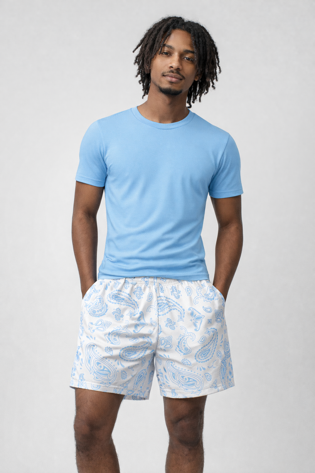 Man wearing a blue t-shirt and RF-Wear Men's Mesh Paisley Shorts in White/Sky Blue 