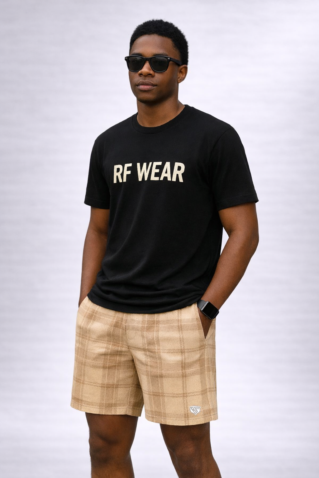 Man wearing a black t-shirt and RF-Wear Men's Mesh Plaid Shorts in Cream /Tan 