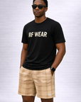 Man wearing a black t-shirt and RF-Wear Men's Mesh Plaid Shorts in Cream /Tan 