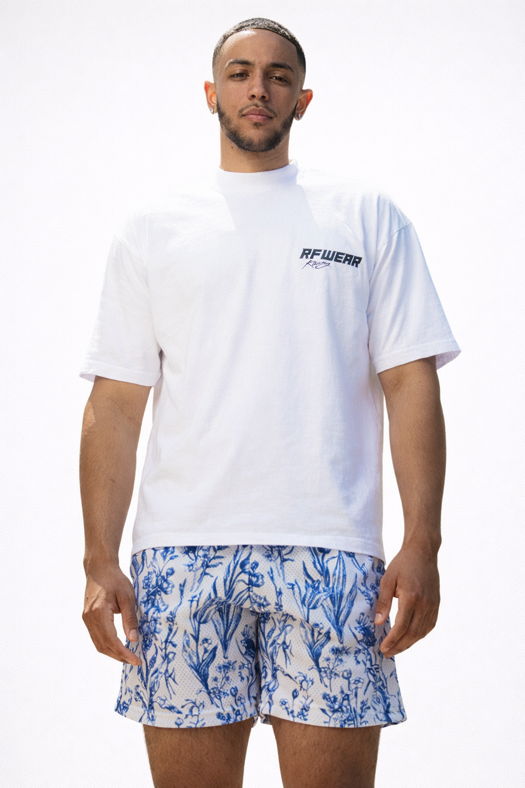 Man wearing a white t-shirt and RF-Wear Mens Mesh Floral Porcelain Shorts in White/Blue 