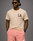 Man wearing a natural color t-shirt and RF-Wear Men's Mesh Floral Rose Shorts in Pink
