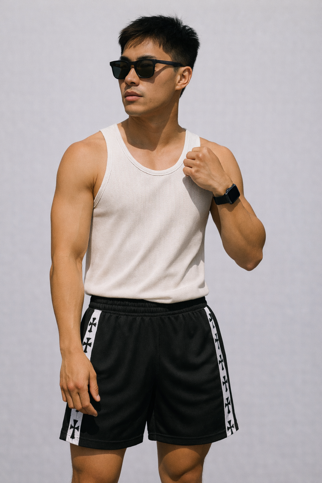 Man wearing a white top and RF-Wear Men's Mesh Cross Trim Shorts in black with white cross trim.