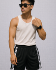 Man wearing a white top and RF-Wear Men's Mesh Cross Trim Shorts in black with white cross trim.